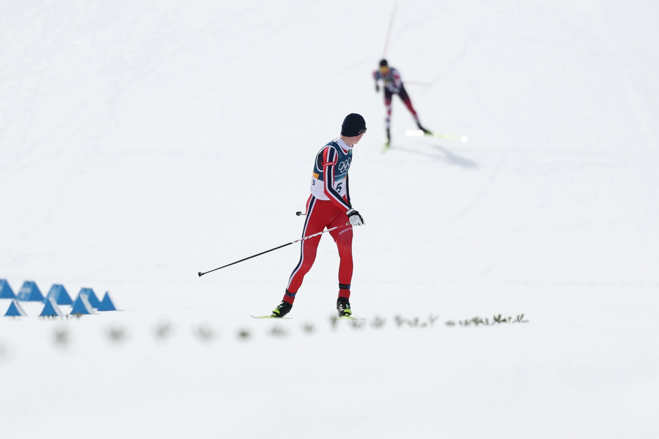 Norway's Jens Luraas Oftebro checks behind him before crossing the finish to win gold