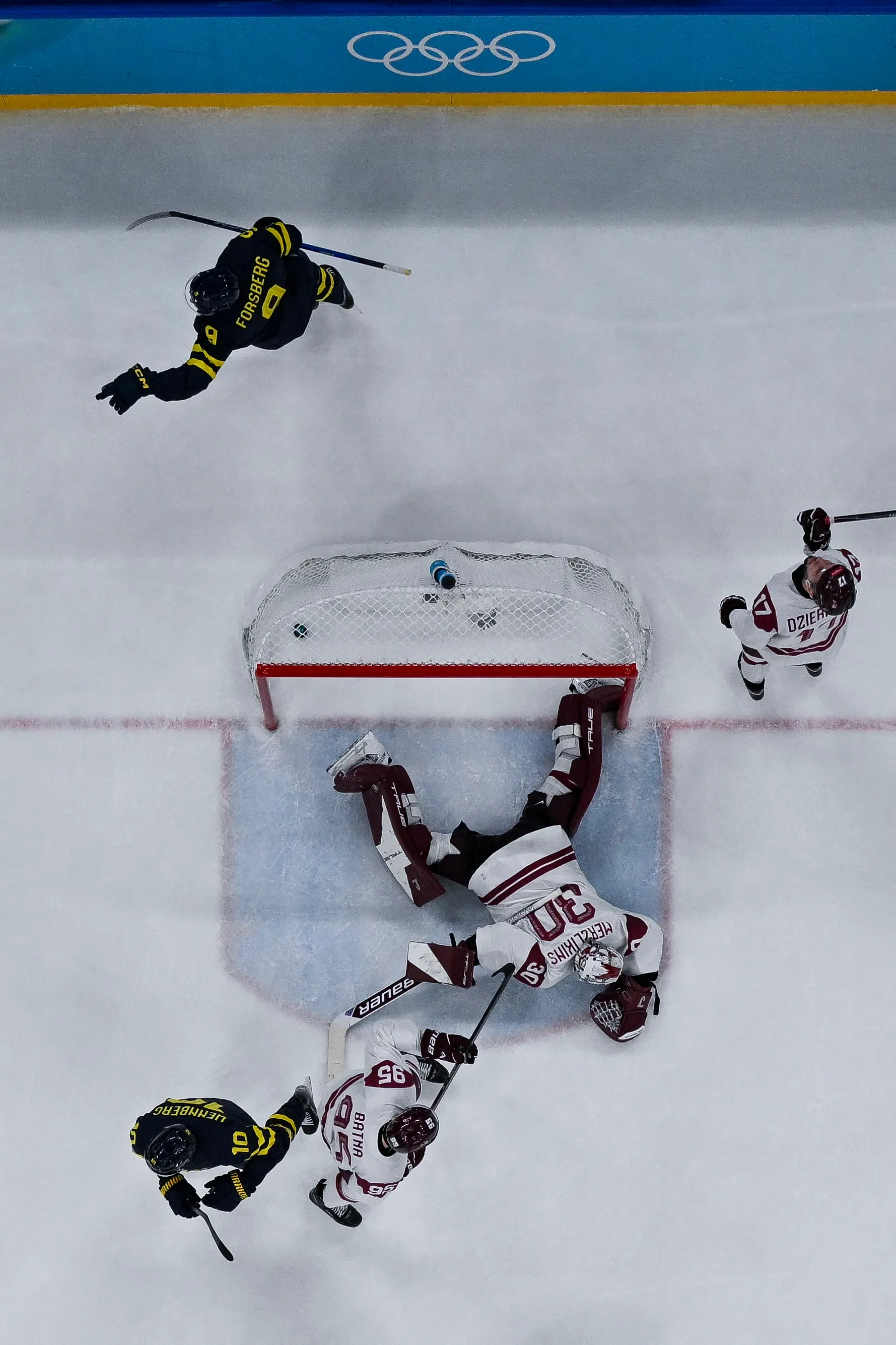 Sweden's #09 Filip Forsberg (top) celebrates after scoring their 3-0 goal during the men's qualification play-off hockey match between Sweden and Latvia.