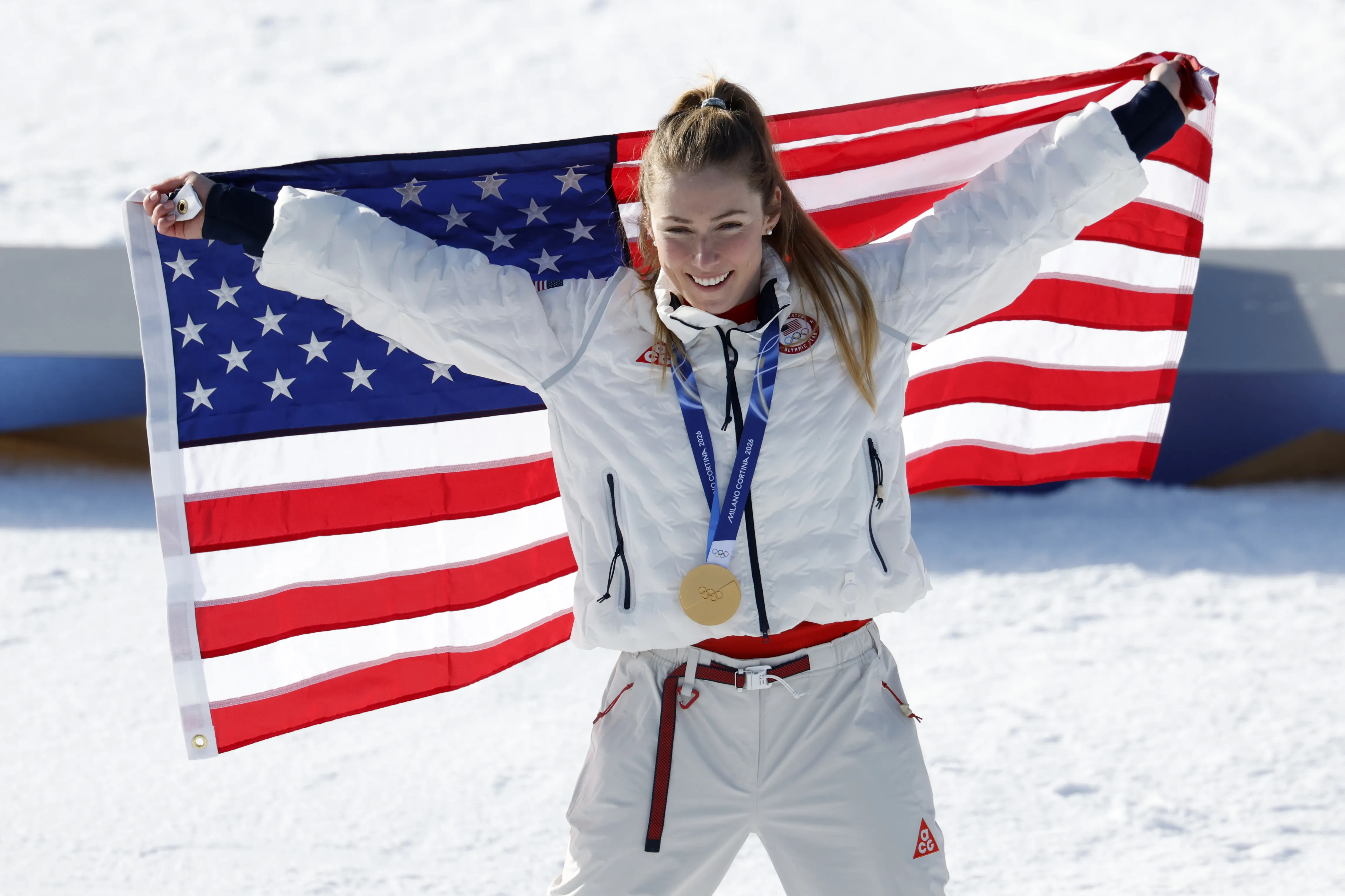 Mikaela Shiffrin posing with American flag and gold medal