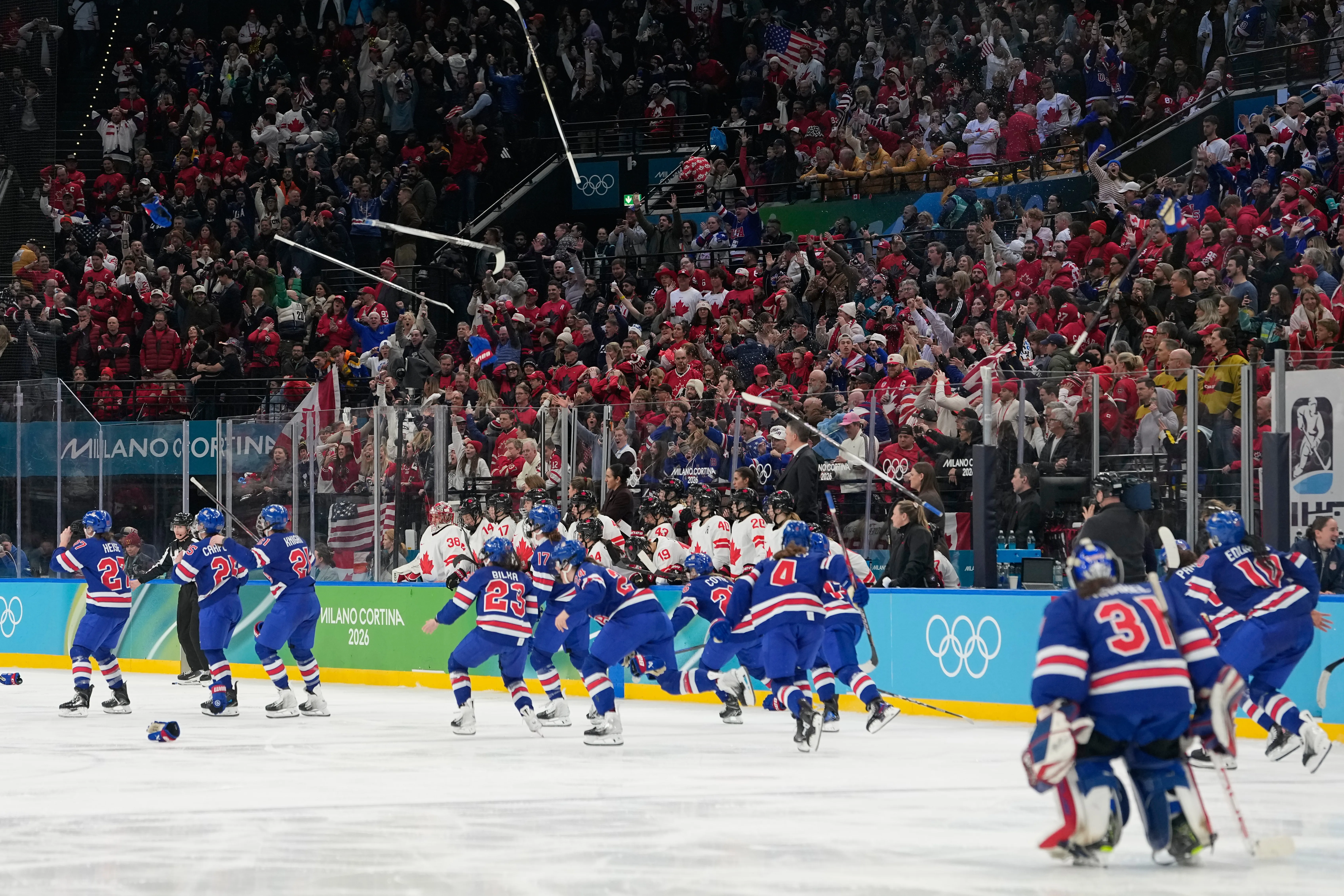 United States players celebrate after a women’s ice hockey gold...