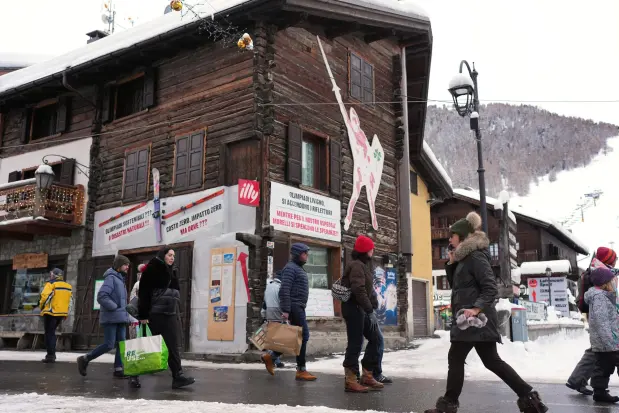 People walk through a street during the 2026 Winter Olympics, in Livigno, Italy, Monday, Feb. 16, 2026. (AP Photo/Andy Bao)