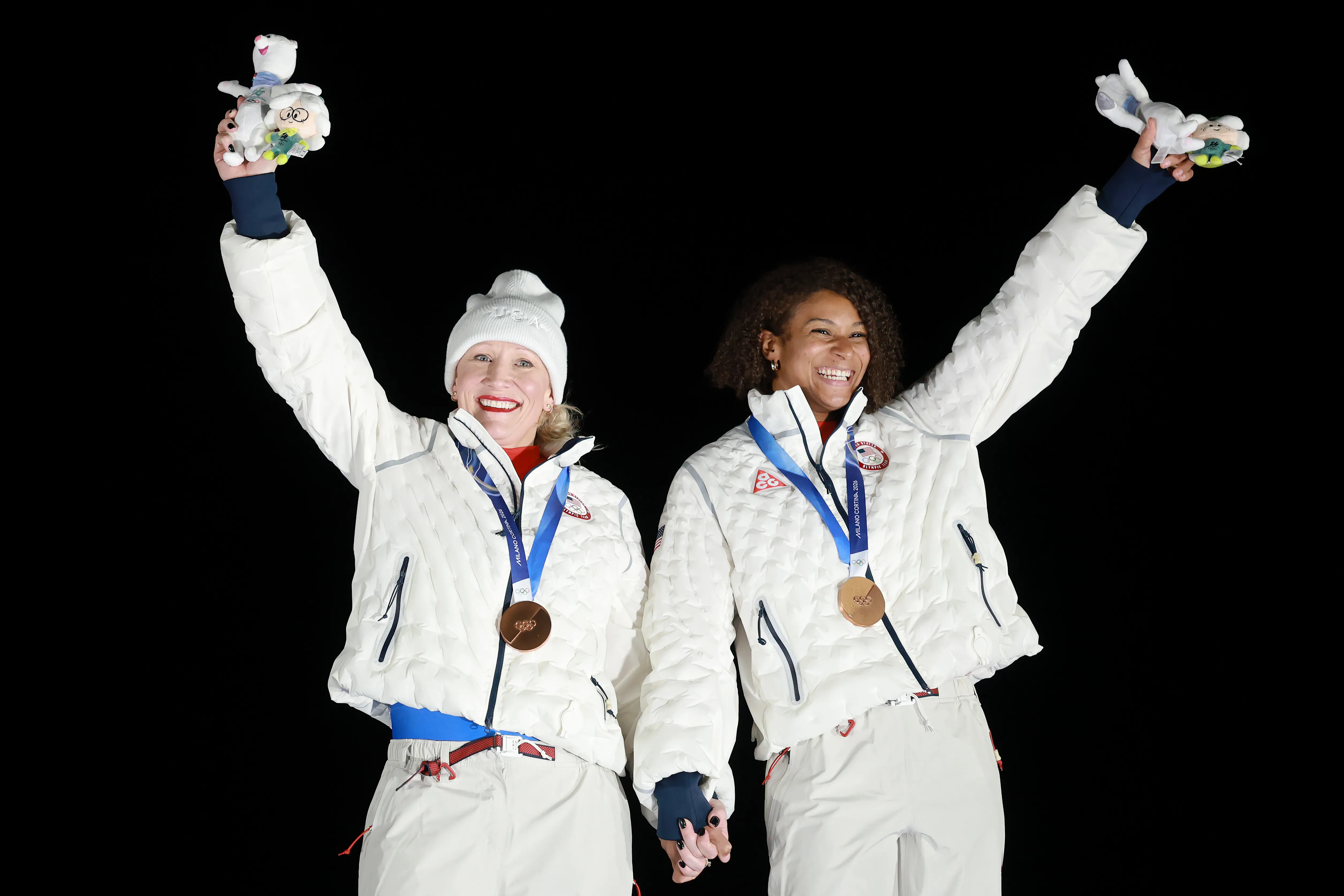 Bronze medalists Kaillie Armbruster Humphries and Jasmine Jones of Team United States celebrate on the podium during the medal ceremony for the Bobsleigh Two-Woman event. 
