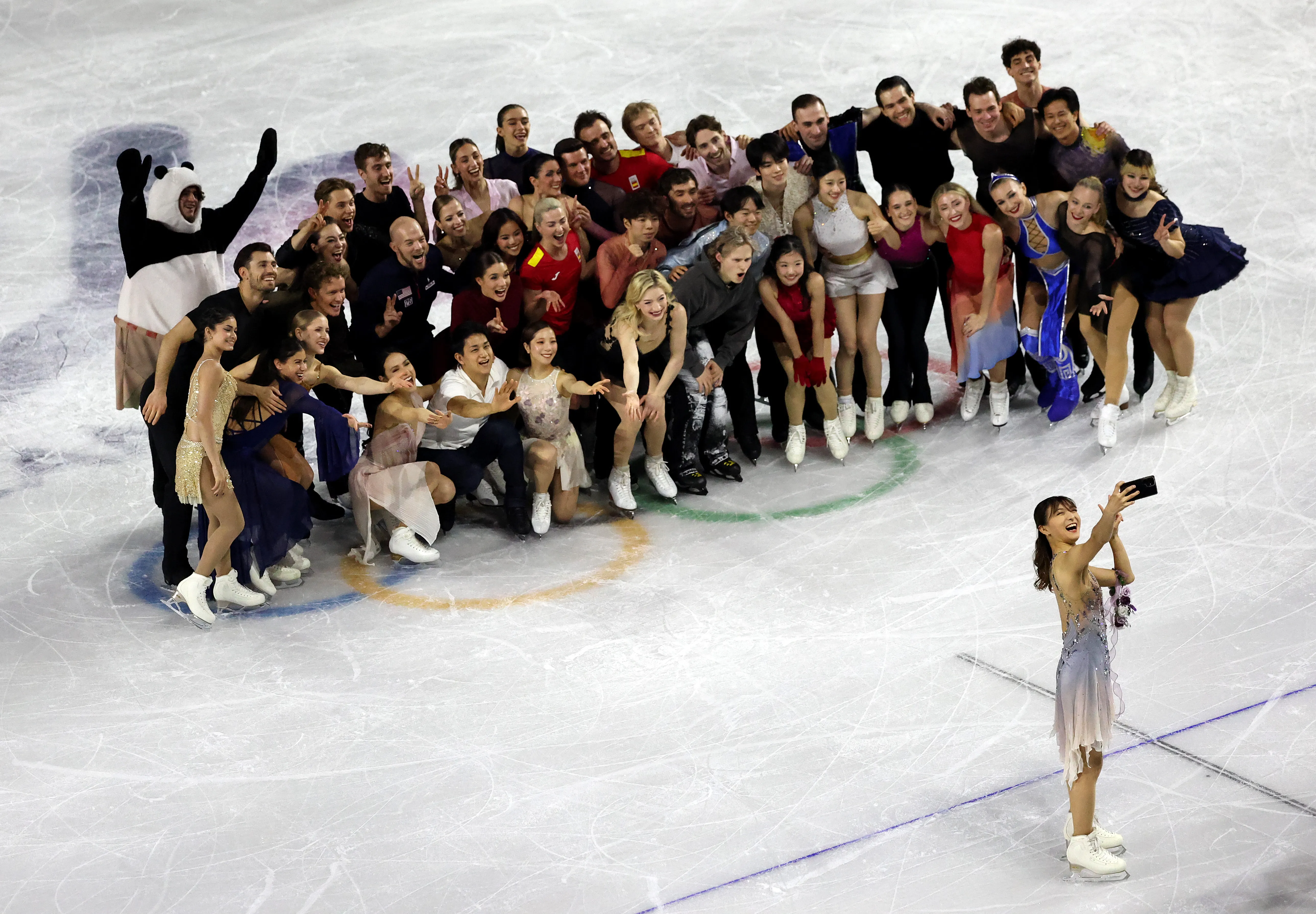Kaori Sakamoto of Team Japan poses for a selfie with athletes during a Figure Skating Exhibition Gala.