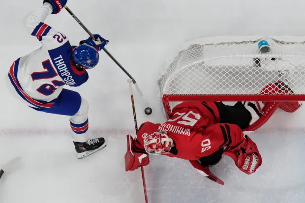 United States' Tage Thompson (72) challenges with Canada's Jordan Binnington (50) during a men's ice hockey gold medal game between Canada and the United States at the 2026 Winter Olympics, in Milan, Italy, Sunday, Feb. 22, 2026. (AP Photo/Nikos Seimenakis)