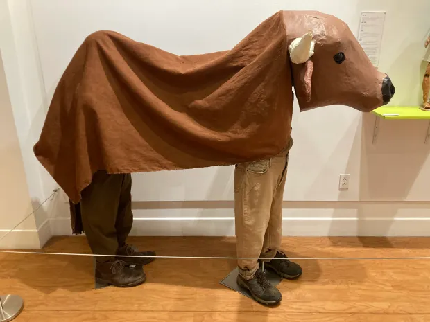 A bull puppet in the "Somos Uno: Mexican and Mexican American Puppetry" exhibit has realistic puppeteer legs attached. (Christopher Arnott/Hartford Courant)