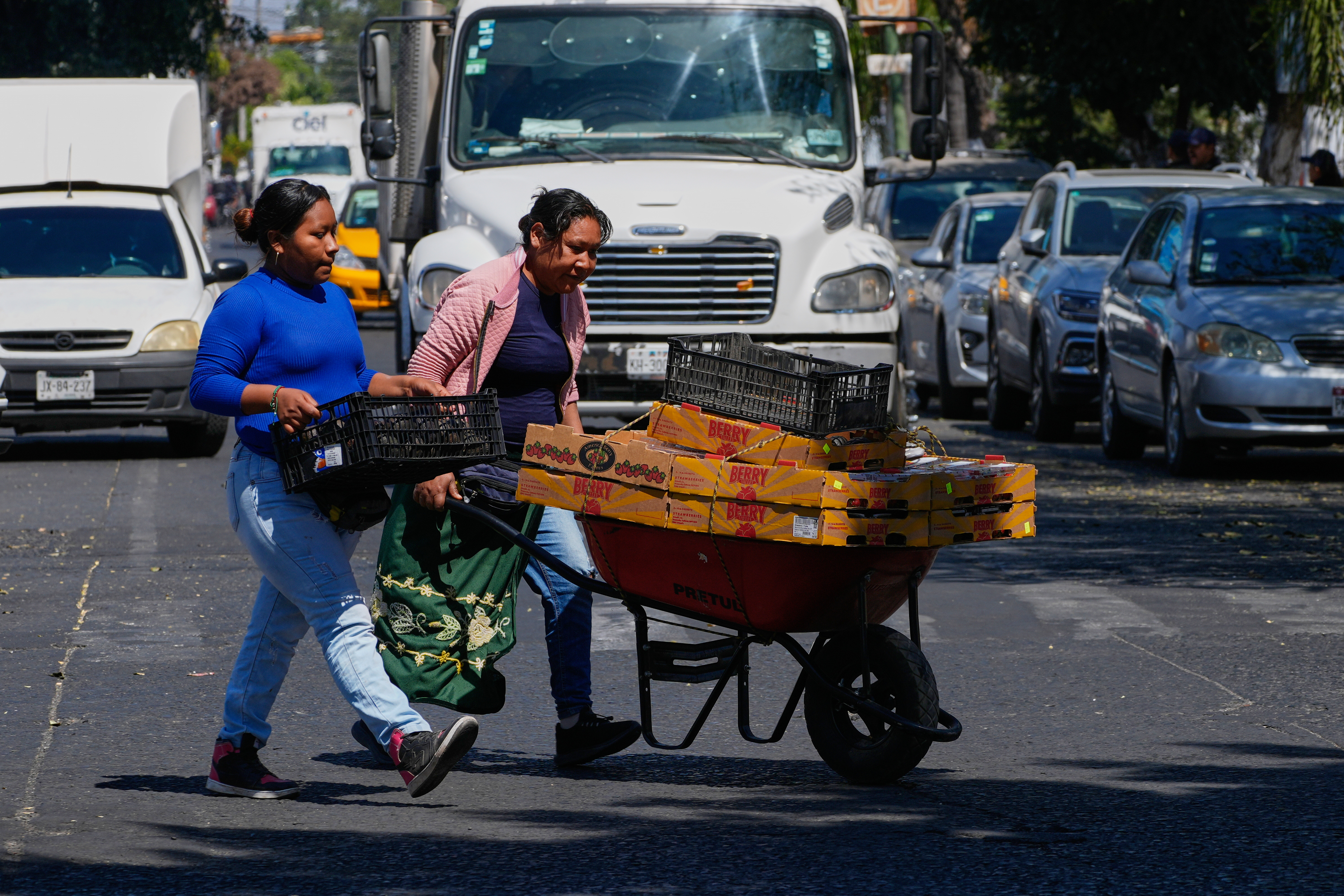 Fruit vendors walk along a street in Guadalajara, Mexico.