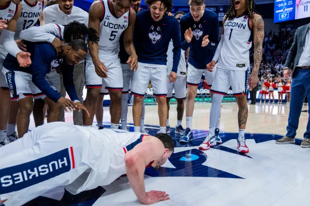 UConn captain Alex Karaban kisses the Husky logo at center court at Gampel Pavilion following a 71-67 Senior Day win over Seton Hall on Saturday. (Joe Buglewicz/Getty Images)