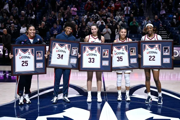 UConn Seniors Ice Brady (25), Ayanna Patterson (34), Caroline Ducharme (33), Azzi Fudd (35) and Serah Williams (22) pose for a photograph as they are honored in a post game Senior Day ceremony after an NCAA college basketball game against Providence, Sunday, Feb. 22, 2026, in Storrs, Conn. (AP Photo/Jessica Hill)