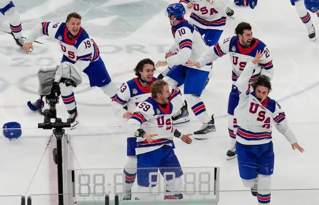 Jack Hughes celebrates with teammates after scoring the winning goal against Canada in the gold medal game.