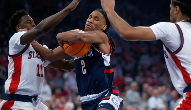 UConn guard Silas Demary Jr, middle, drives between St. John's guard Ian Jackson, left, and forward Bryce Hopkins during the first half of an NCAA college basketball game Friday, Feb. 6, 2026, in New York. (AP Photo/John Munson)
