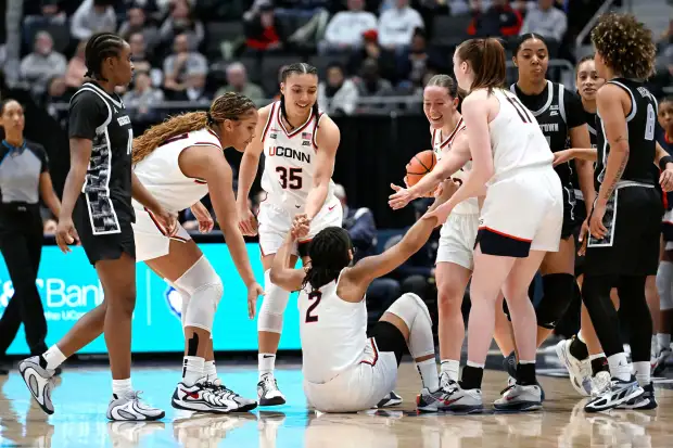 UConn's Sarah Strong, second from front left, Azzi Fudd (35) Ashlynn Shade, fifth from right, and Allie Ziebell, fourth from right, help up teammate KK Arnold (2) in the first half of an NCAA college basketball game against Georgetown, Thursday, Feb. 26, 2026, in Hartford, Conn. (AP Photo/Jessica Hill)