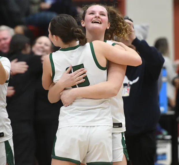 Northwest Catholic's Abigail Casper hugs her younger sister Samantha (15) after Northwest Catholic won the CCC girls basketball tournament championship 72-34 over Rocky Hill Monday night at the University of Hartford. (Photo by Lori Riley)