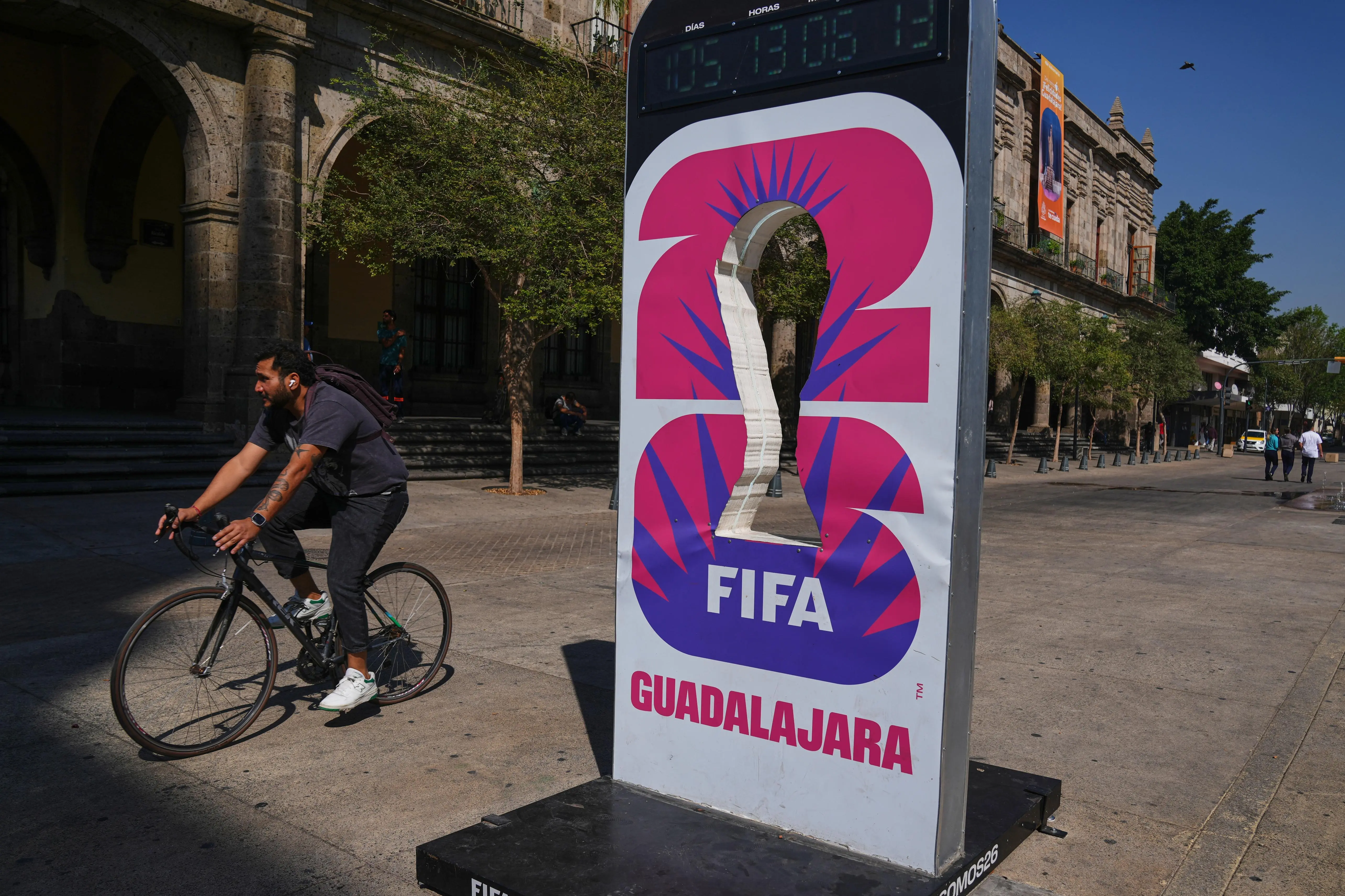A cyclist rides past an installation promoting the FIFA World...