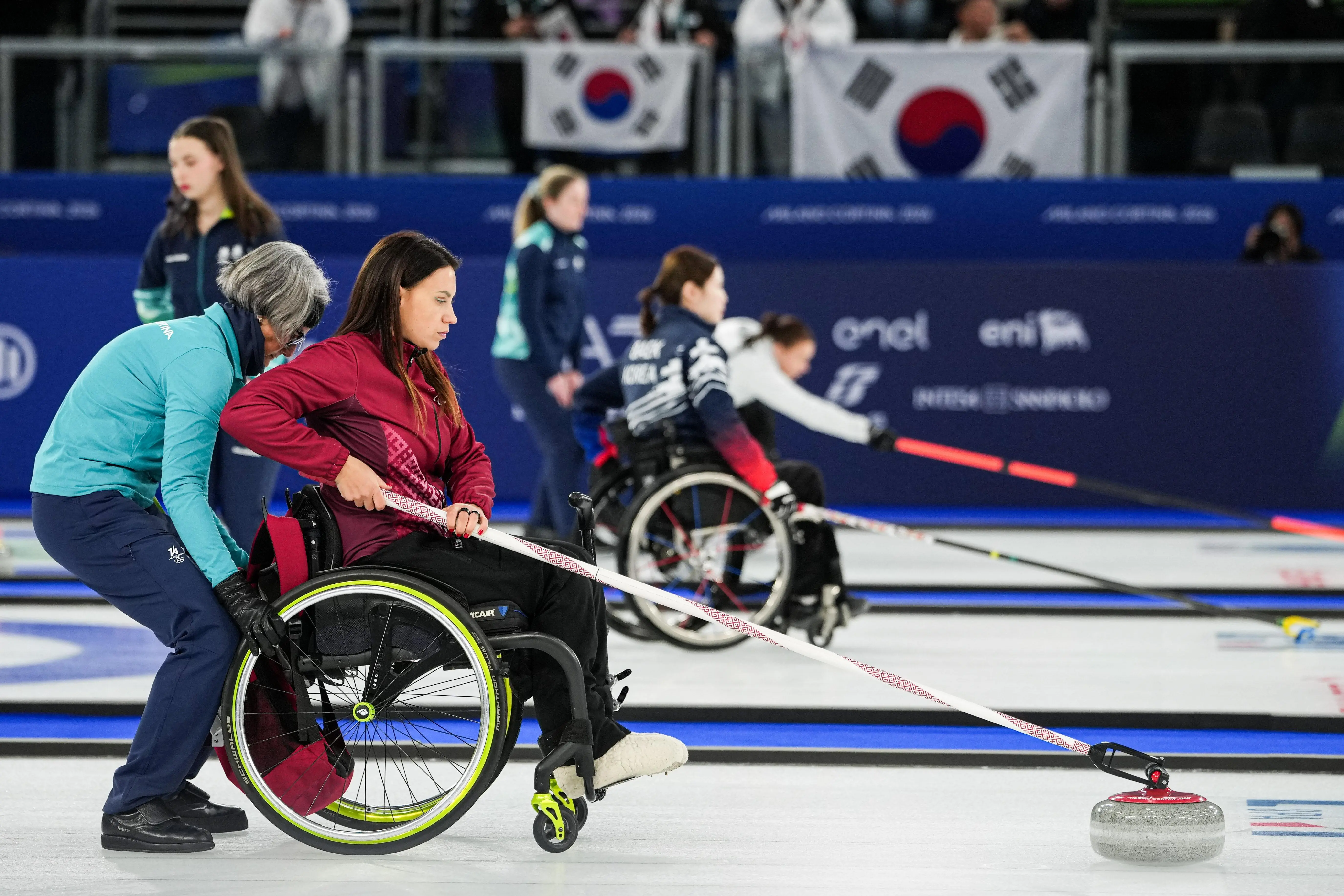 Polina Rozkova of Latvia, pushes a stone during a wheelchair curling mixed doubles round robin session.