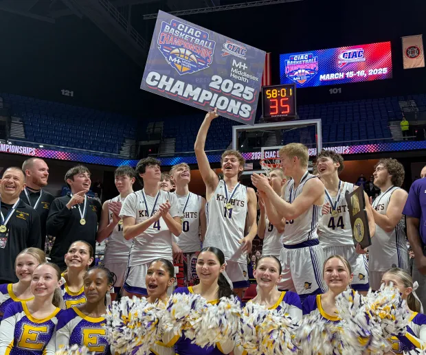 The Ellington boys basketball team celebrates their state championship and perfect season with the cheerleaders after beating Sheehan 55-39 Sunday afternoon at Mohegan Sun. (Photo by Lori Riley)