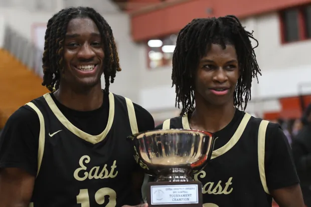 Kehari Walker (left) and Zasheem McCoy hold the CCC championship trophy after East Hartford defeated Windsor in the final at the University of Hartford Monday night. (Photo by Lori Riley)