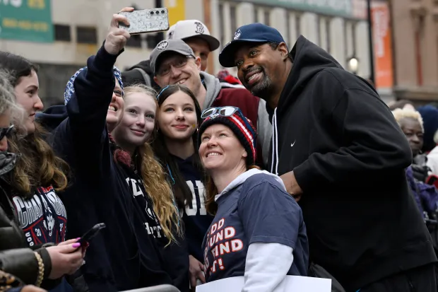 Katie and Tim Fudd, parents of UConn guard Azzi Fudd pose for photos during a parade celebrating the Huskies' NCAA women's college basketball championship, Sunday, April 13, 2025, in Hartford, Conn. (AP Photo/Jessica Hill)