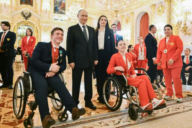 FILE - Russian President Vladimir Putin, second left, poses for a photo with Russian Paralympic athletes Aleksei Churkin, front left, who won a silver medal in shot put, and Evgeniia Galaktionova, front right, who won a bronze medal in javelin throw, after an awarding ceremony for the Russian Paralympic Committee's medalists of the Paris 2024 Paralympics in Moscow, Russia, Monday, Dec. 16, 2024. (Kristina Kormilitsyna, Sputnik, Kremlin Pool Photo via AP, File)