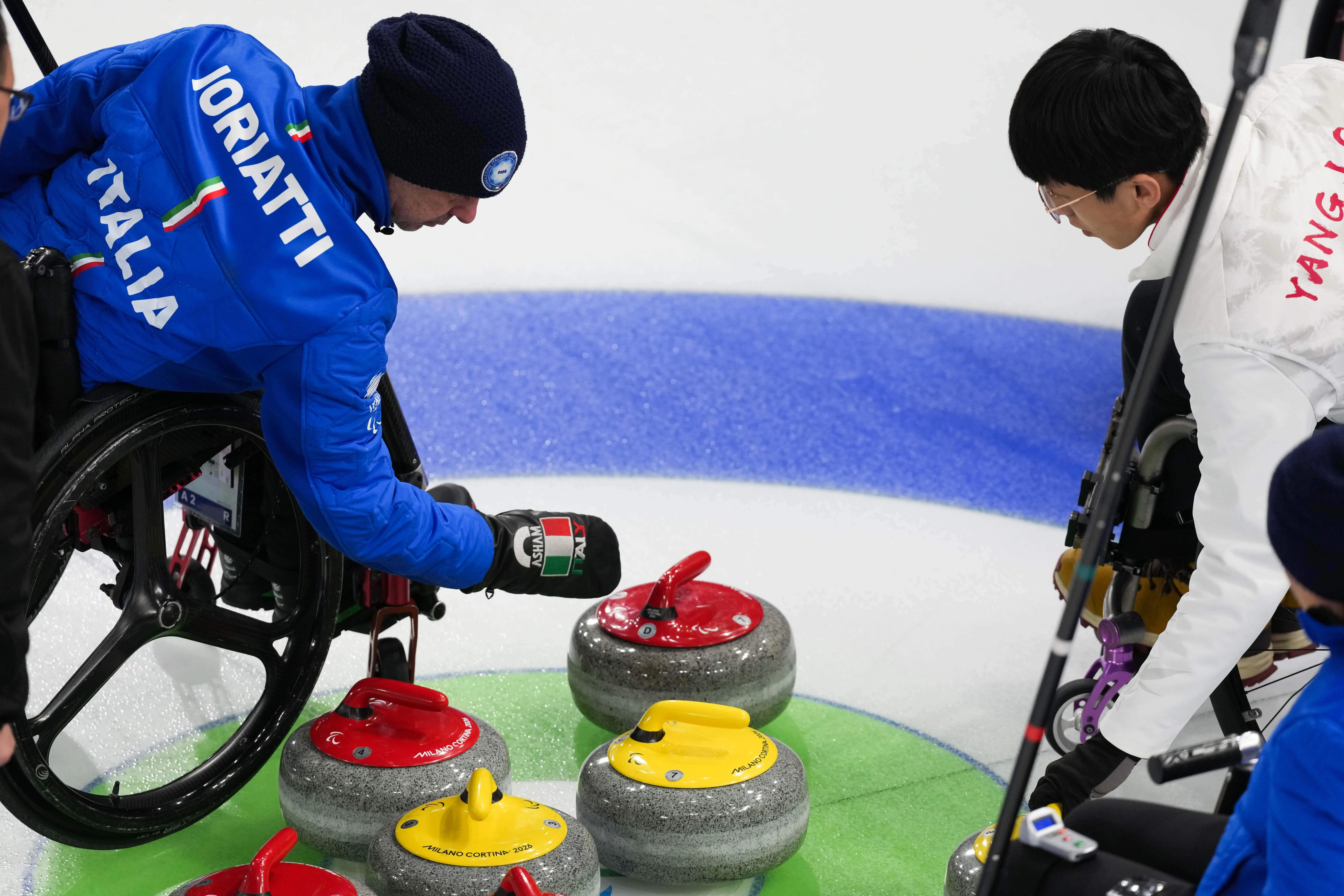 Paolo Ioriatti, of Italy, and Jinqiao Yang, of China, look at curling stones.