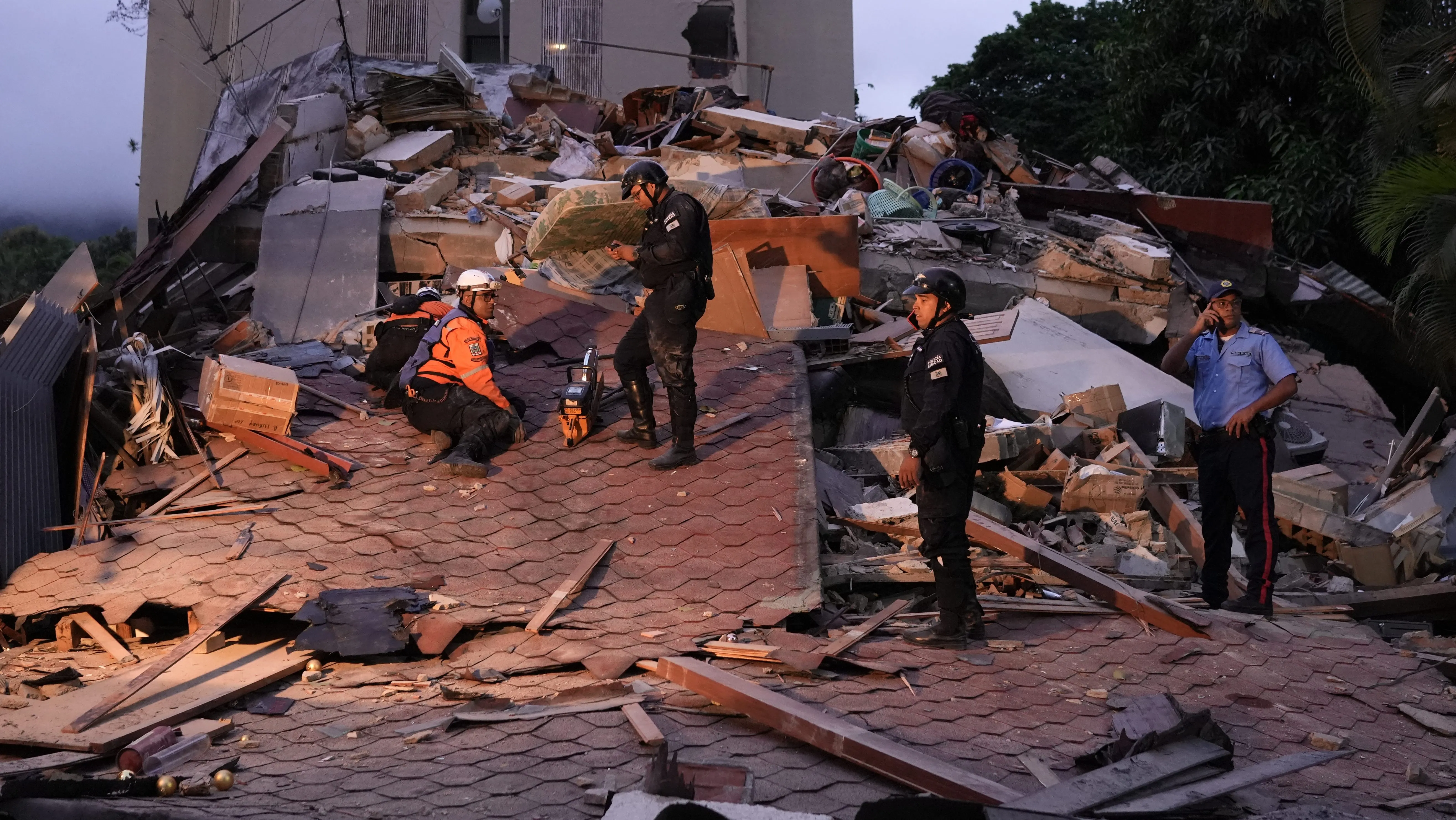 Rescue workers and municipal police officers work at the site of a collapsed building following an earthquake in Caracas on June 24, 2026. 